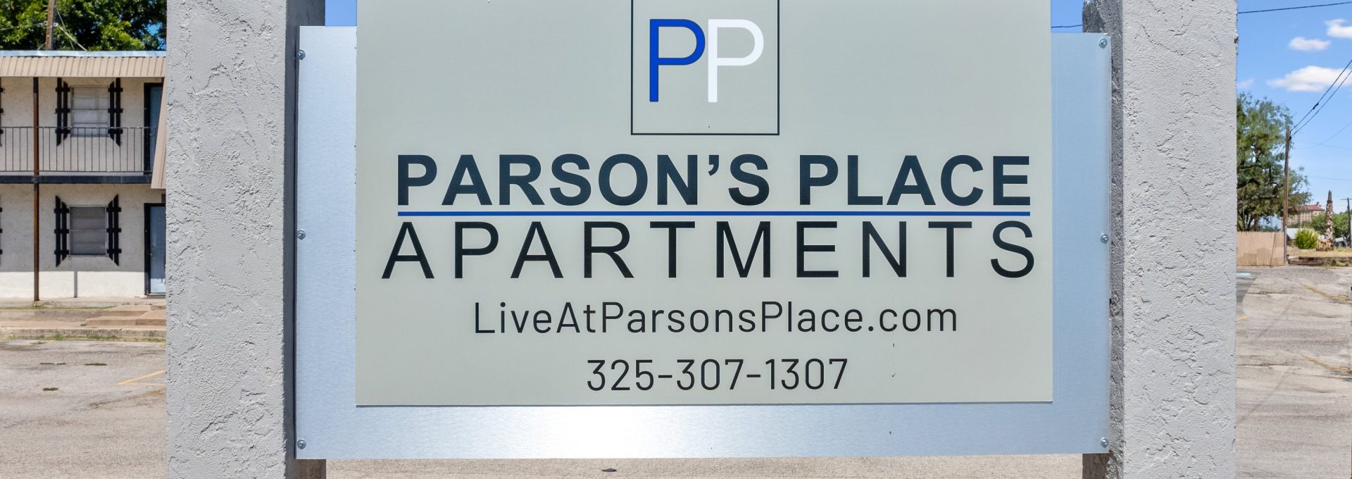 a sign for parsons place apartments with a blue sky at The Parsons Place